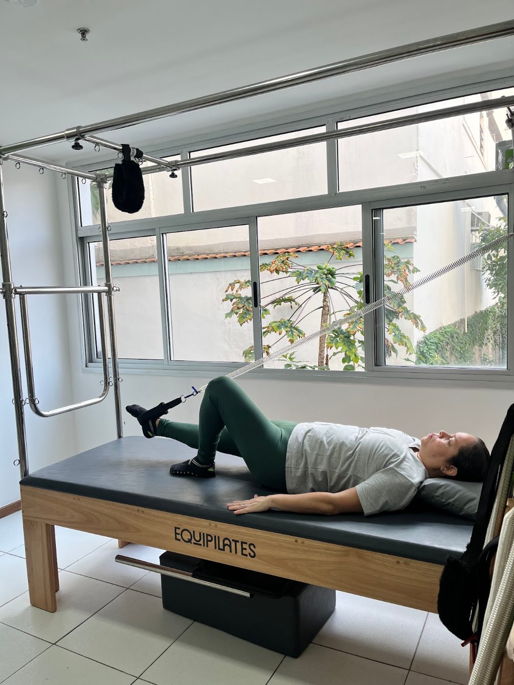 Aluna fazendo exercício no Cadillac durante aula de Pilates